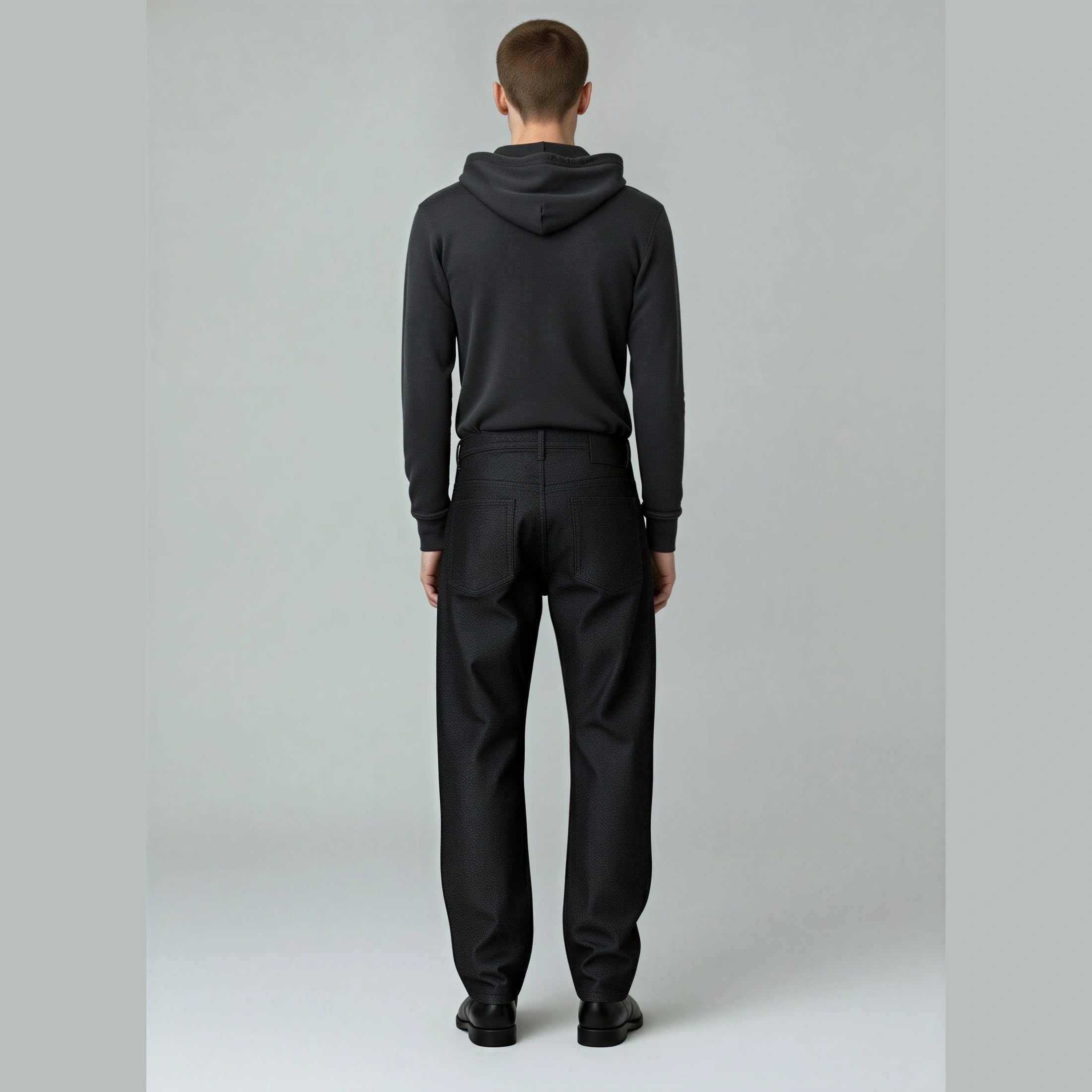 Model wearing RAW BLACK DENIM straight-leg jeans from back highlighting mid-rise fit and pocket stitching
