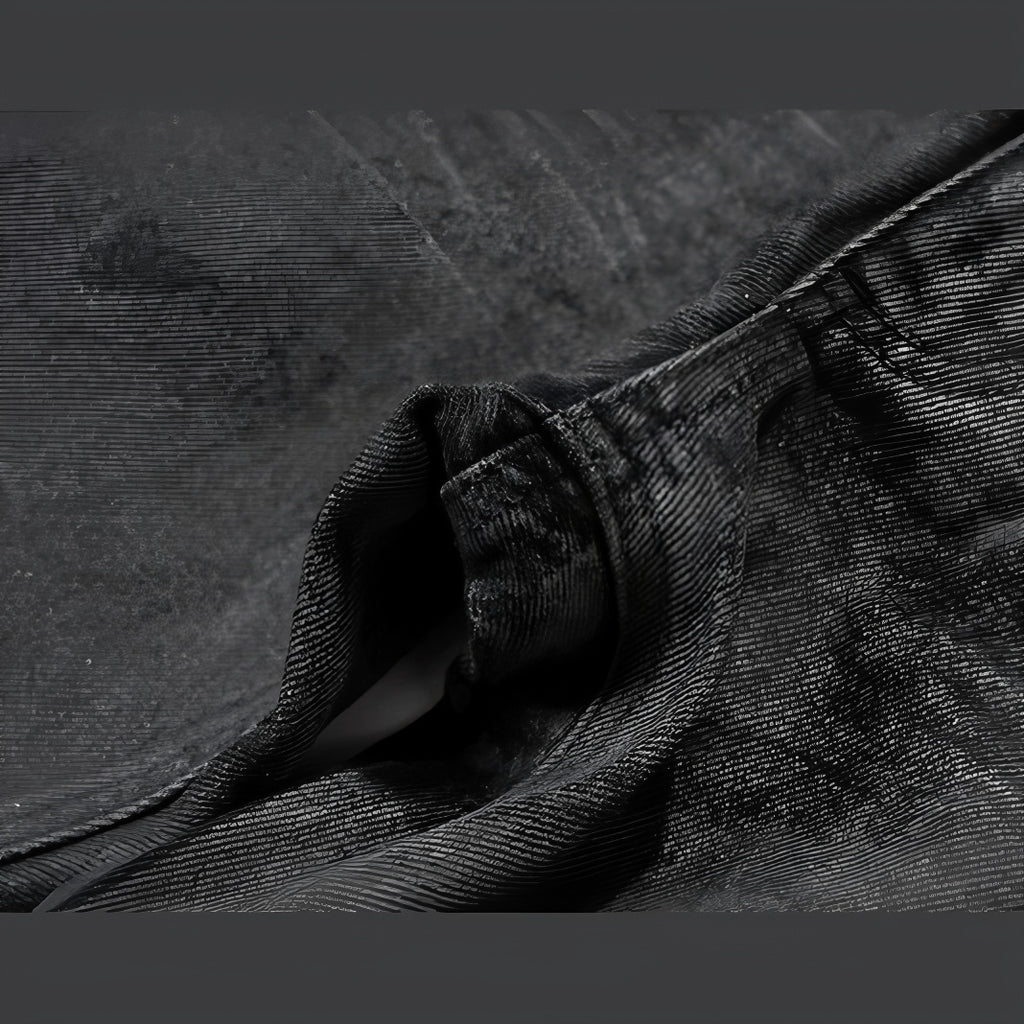 Folded hem detail of black tonal camo denim with stitching