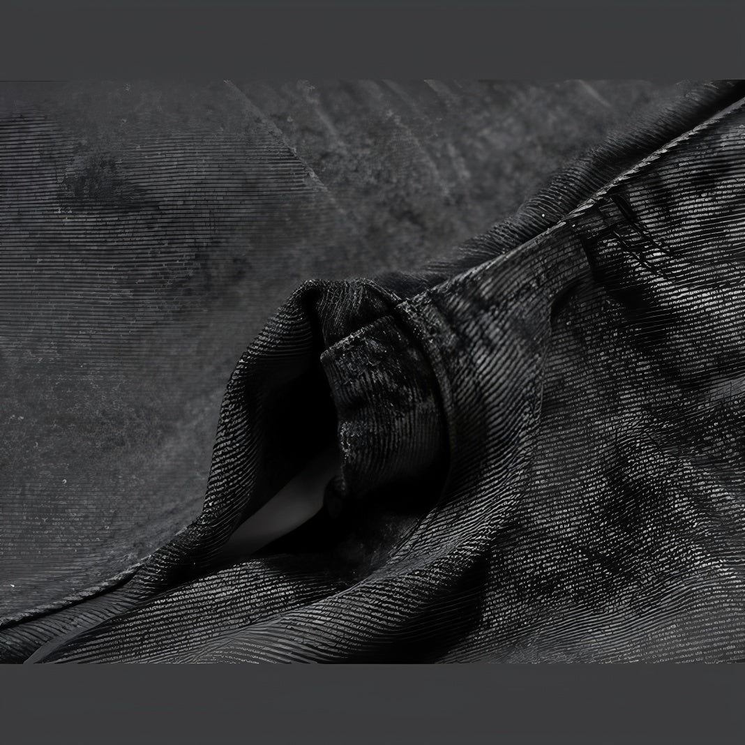 Folded hem detail of black tonal camo denim with stitching